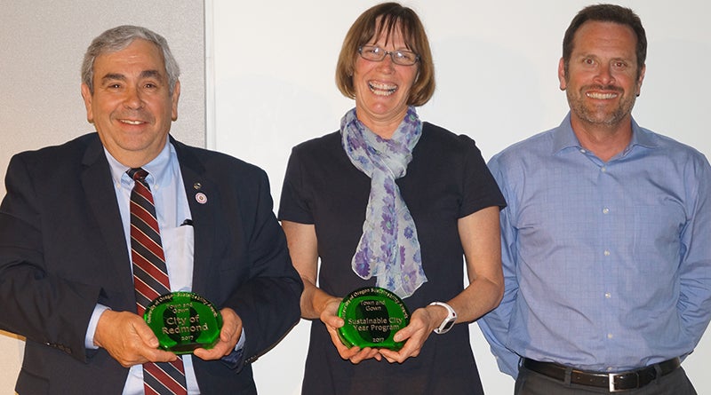 From left, City of Redmond Mayor George Endicott, Megan Banks, and Redmond City Manager Keith Witcosky celebrate their 2017 Town and Gown UO Sustainability Award.