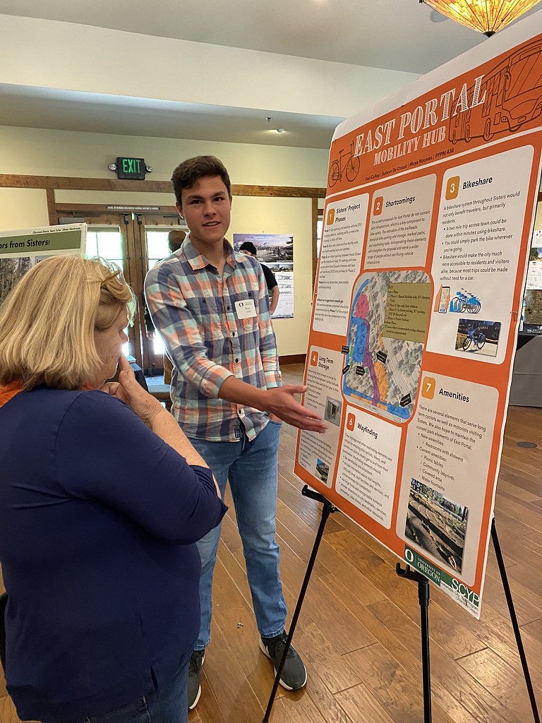 Student explaining their findings to a community member during the spring report. 