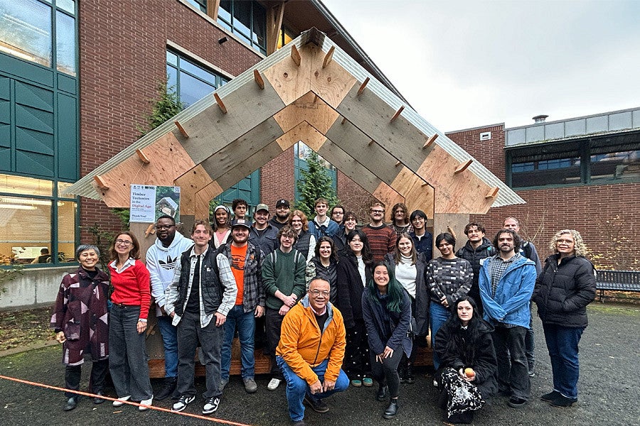 Timber Tectonics proposed shelter for Tualatin. Shows students smiling with city officials in front of the proposed structure. 