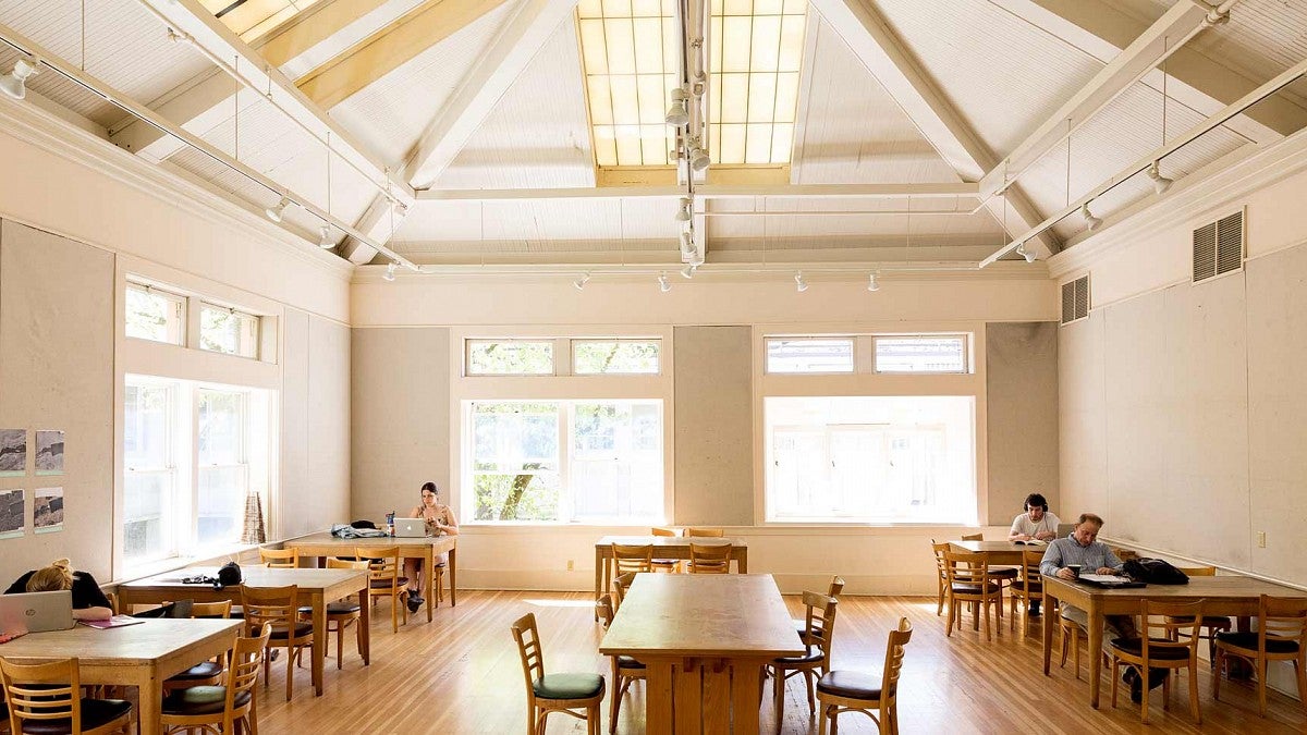 The Wilcox Hearth with vaulted ceiling, wood floor, and students studying at tables