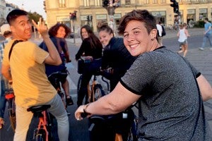 Portrait of Finley Heeb on a bike in a European city