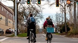 Two people on bikes at intersection